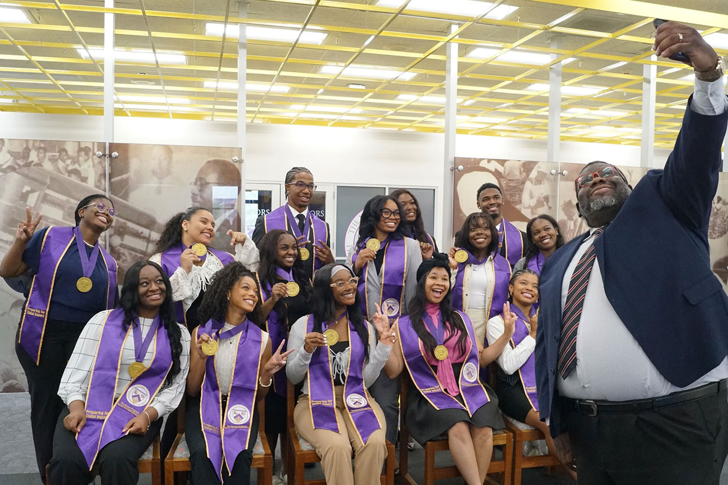 Group of Honors College students smiling and showing their award medallions