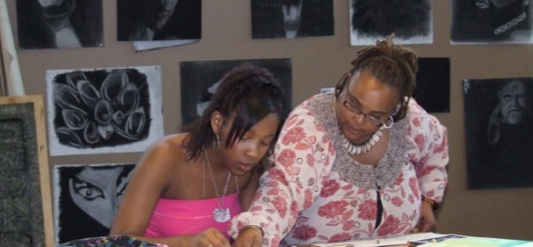 Johnson (right) helps a student during class.