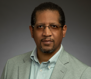 Dr. MIchael Royster's headshot. He is wearing a green coat.