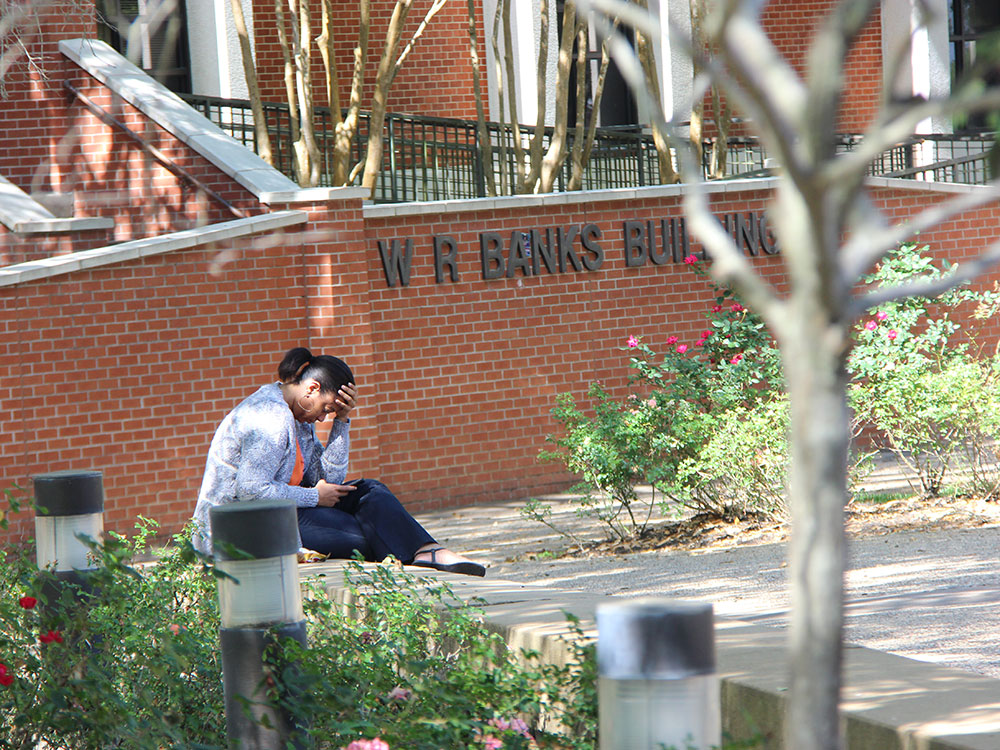 Student sitting outside the W.R. Banks building
