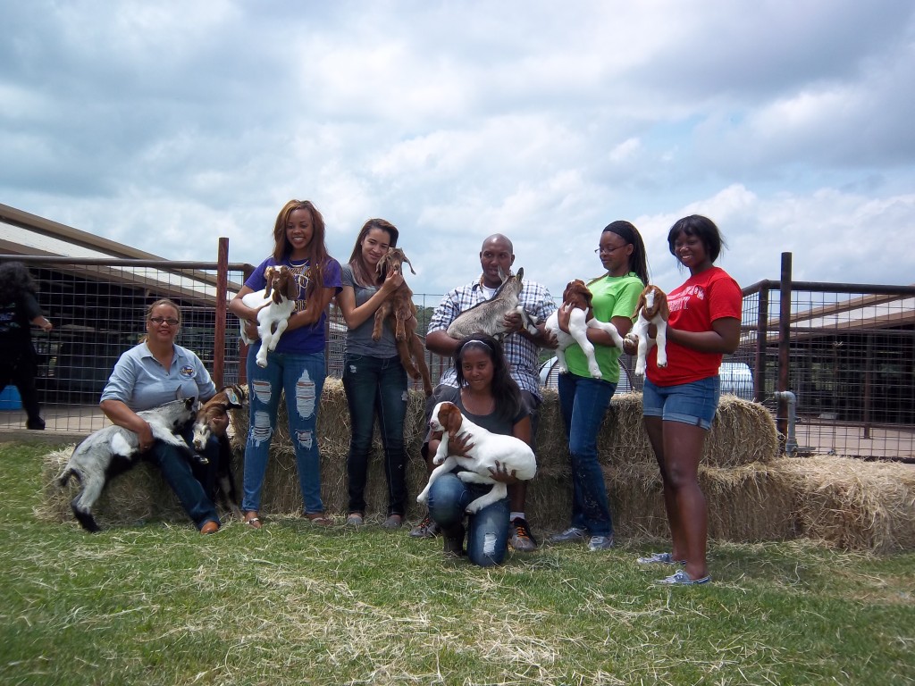 Students posing with kid goats at the PVAMU farm