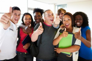 delighted young students making a thumbs up sign