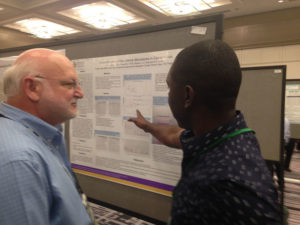 Dr. Newton inspects research poster during session