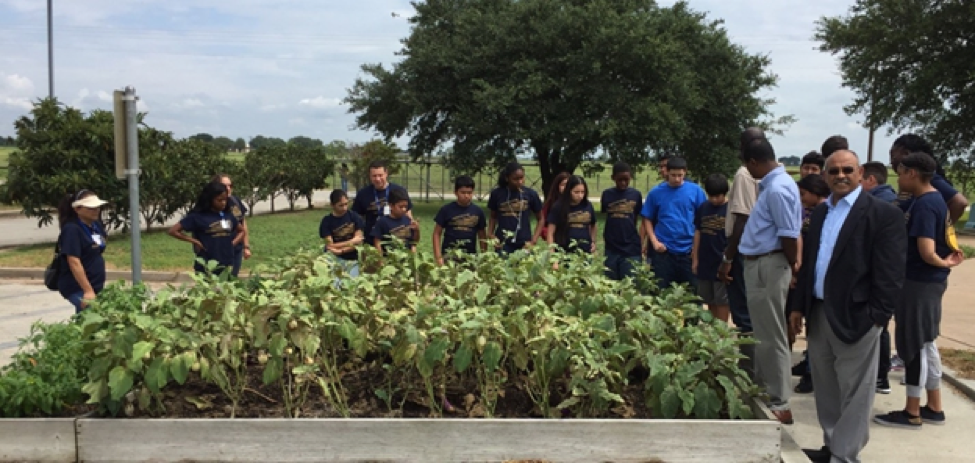 Middle School Students from Houston and Spring Branch ISD Research Scientists, Peter Ampim and Aruna Weerasooriya, and Associate Director of Research, at the Greenhouse Area.