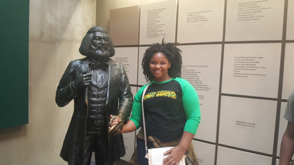 Pictured: Jaimie Landor posing next to Fredrick Douglas’s statue at his National Park Museum.