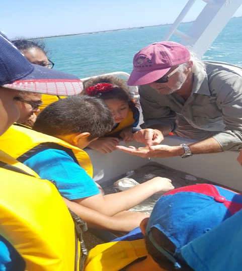 Coastal Marine Agent Tony Reisinger identifying various marine life caught in the net. He discusses the importance of taking care of oceans and the effects on marine life.