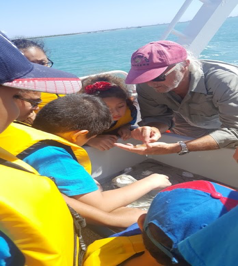 Coastal Marine Agent Tony Reisinger identifying various marine life caught in the net.  He discusses the importance of taking care of oceans and the effects on marine life.