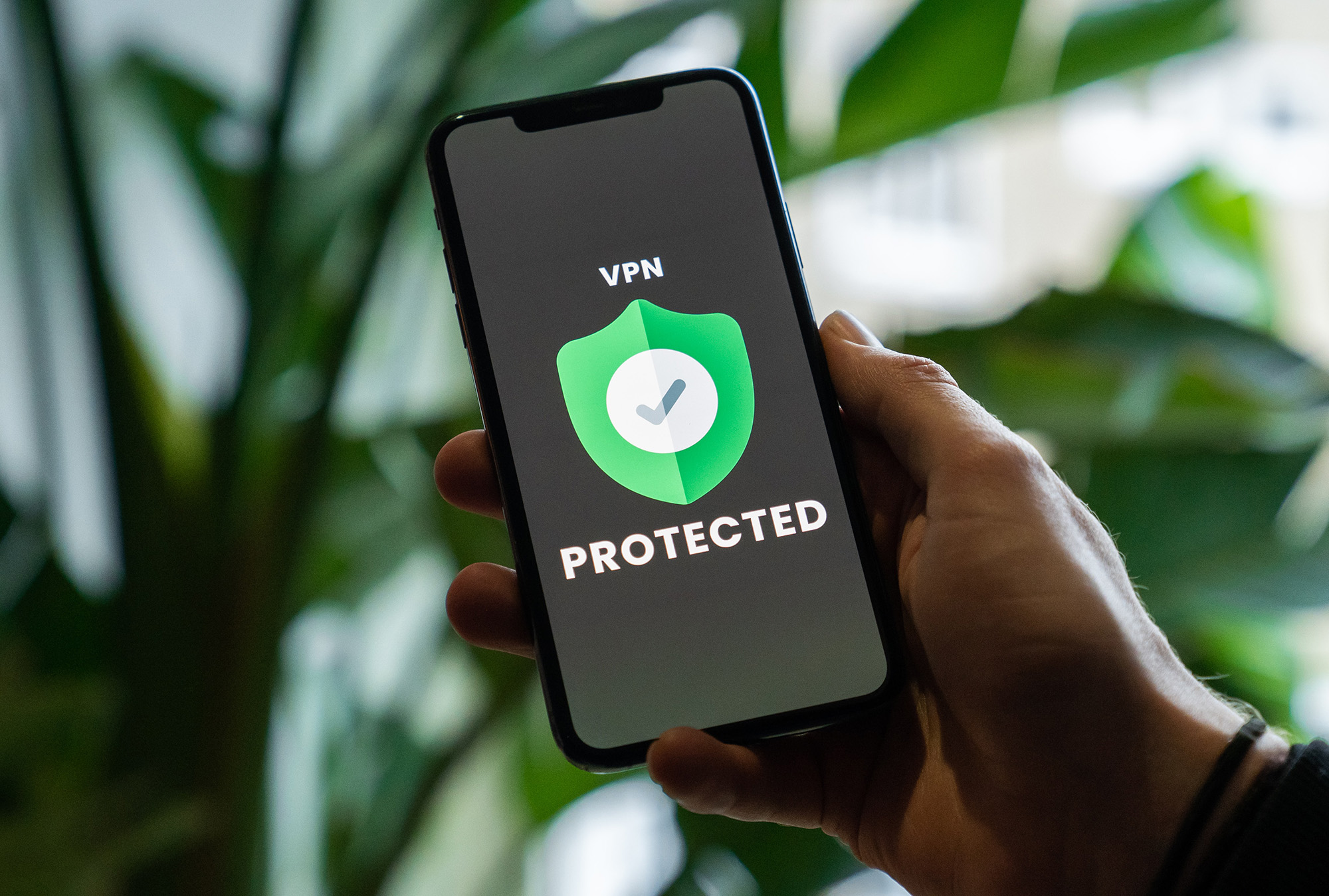 Male holding a cellphone with the words VPN Protected on it
