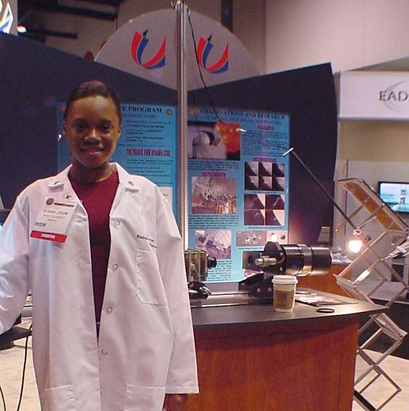 Undergraduate student Quinisha Lipscomb and PVSO display at the World Space Congress 2002.