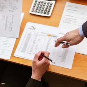 men hands pointing a paper with financial information on it