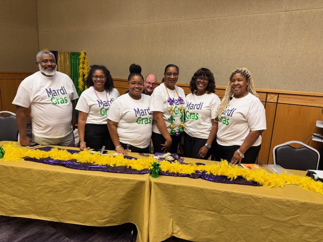 6 members of th executive board standing in front of a table