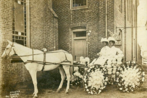 Two women sitting in a buggy decorated with flowers for 1908 Juneteenth Celebration in front of Antioch Baptist Church located in Houston’s Fourth Ward