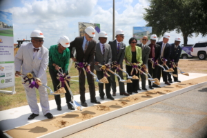 Members of the CAHS leadership team standing side by side holding shovels of dirt