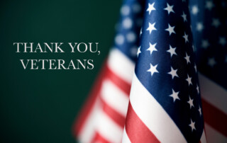 Some American Flags Against a Green Background with Thank You Veterans as the Caption