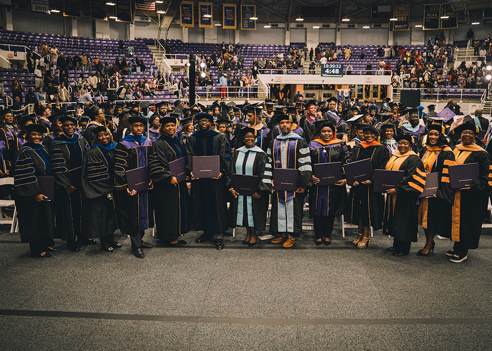 A 2025 graduate shakes hands with PVAMU’s ninth president, Dr. Tomikia P. LeGrande